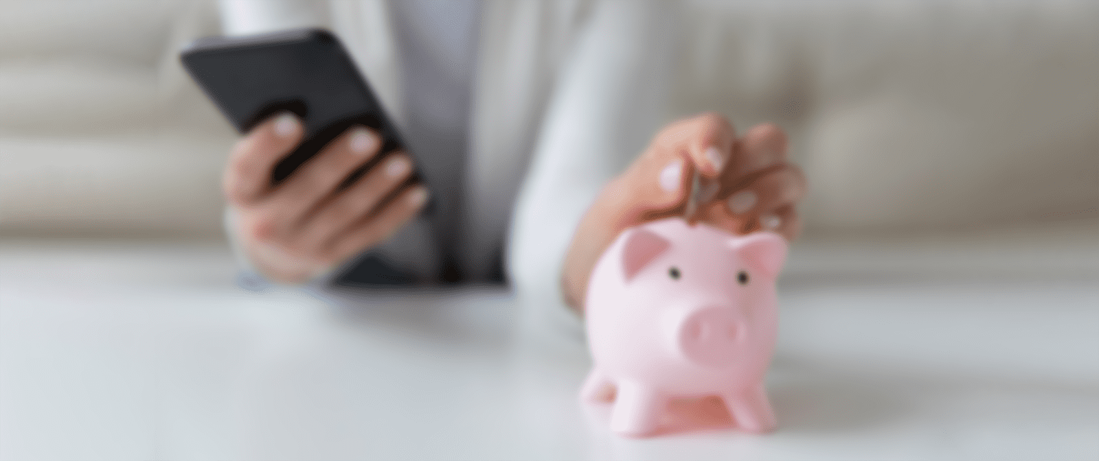 Woman putting money into a piggy bank